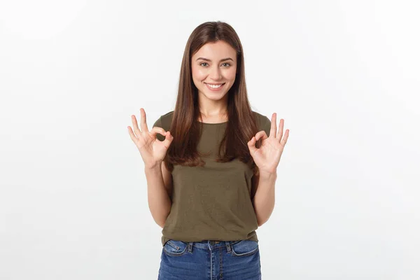 Szczęśliwa młoda kobieta pokazuje ok znak palcami, mrugając na białym tle na szarym tle. — Zdjęcie stockowe