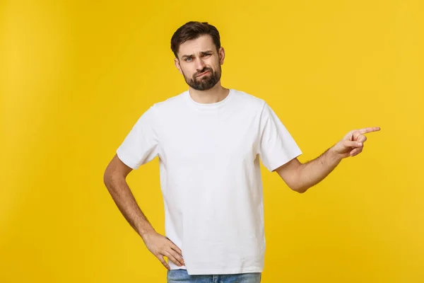 Hombre guapo sobre aislada pared amarilla frustrado y apuntando hacia el frente . —  Fotos de Stock