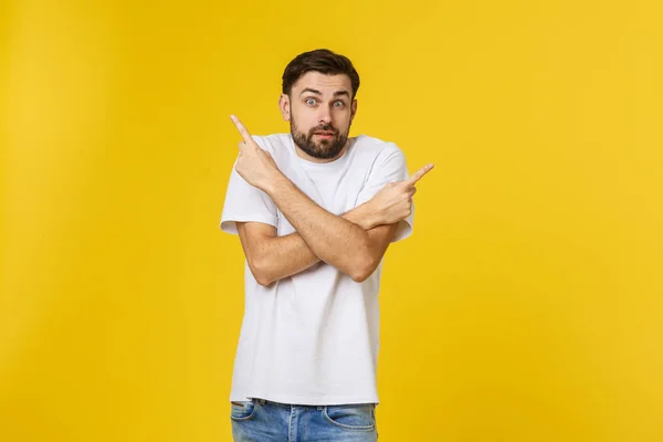 Hombre guapo sobre aislada pared amarilla frustrado y apuntando hacia el frente . — Foto de Stock