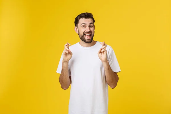 Jongeman doet een wens geïsoleerd op gele achtergrond — Stockfoto