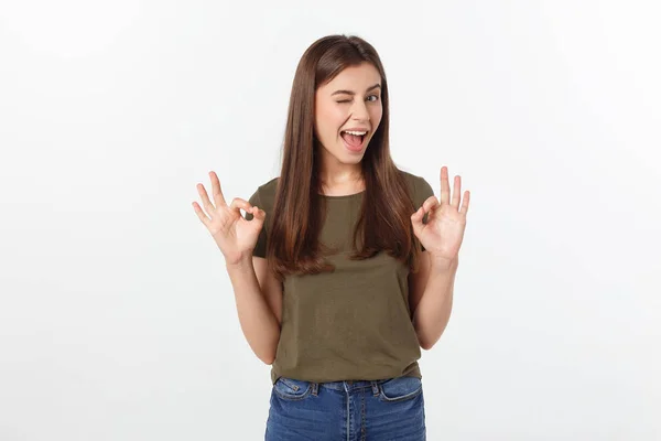 Happy young woman showing ok sign with fingers an winking isolated on a gray background. — Stock Photo, Image