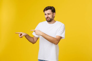 Izole sarı duvar üzerinde Yakışıklı adam sinirli ve ön işaret.