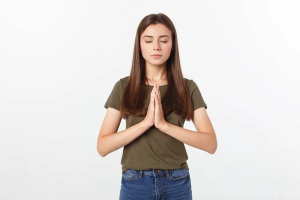 Beautiful young woman in casual clothes holding hands together and praying, isolated on white. — Stock Photo, Image