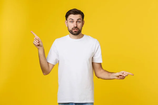 Beau homme sur un mur jaune isolé frustré et pointant vers l'avant . — Photo