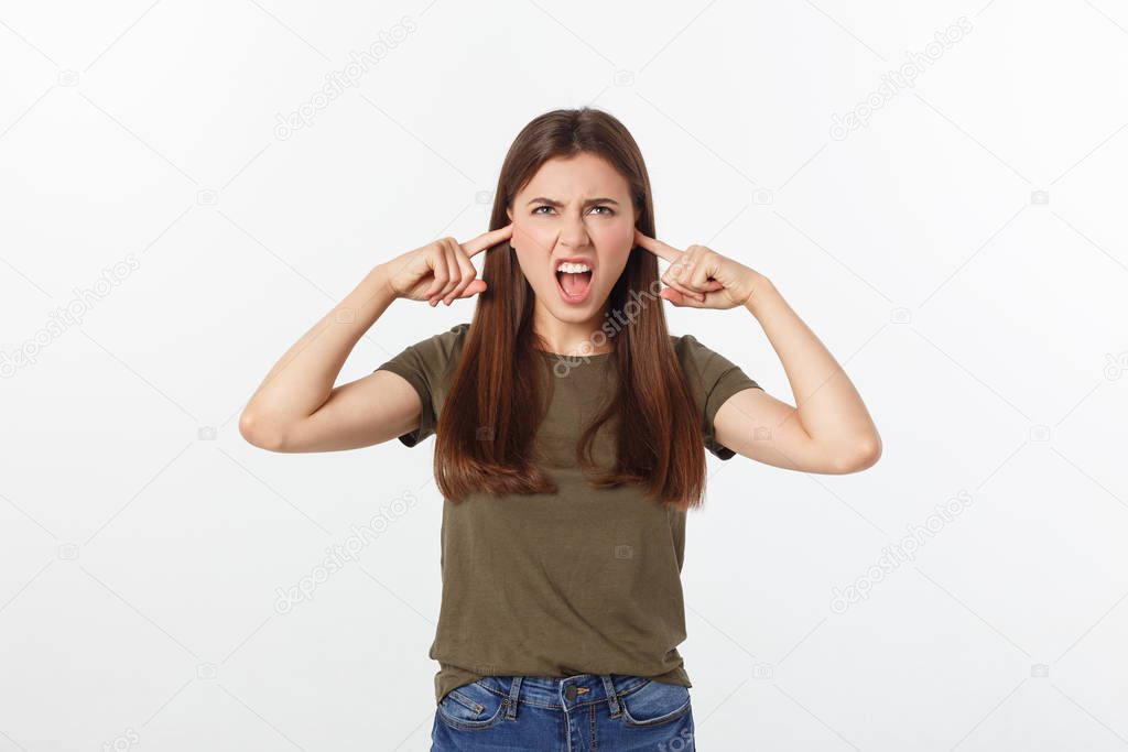 Closeup portrait of a young angry woman covering her ears, stop making that loud noise its giving me a headache, isolated on white background.