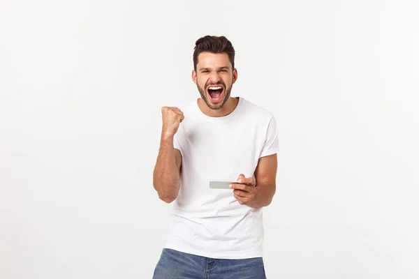 Portret van een jonge man spelen videospelletjes op mobiele telefoon op grijze achtergrond. — Stockfoto