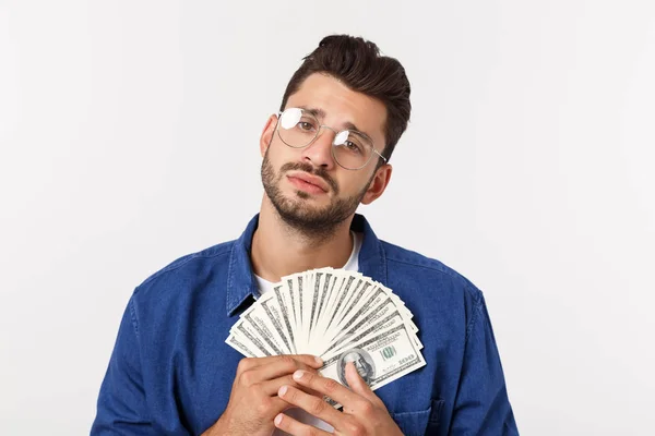 Atractivo hombre está sosteniendo dinero en efectivo en una mano, sobre fondo blanco aislado — Foto de Stock