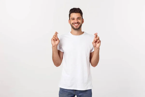 Closeup portrait of young handsome man crossing fingers, wishing, praying for miracle, hoping for the best, isolated on white background. — Stock Photo, Image