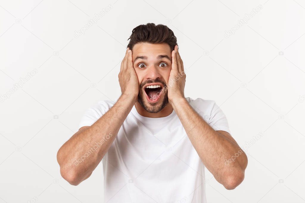 Portrait of young man with shocked facial expression, isolated over white background.