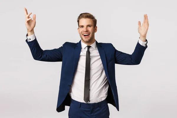 Vrolijke gelukkige en succesvolle mannelijke ondernemer in klassiek pak, handen omhoog verheugd, doel te bereiken, vieren goede deal, verhoogd inkomen, staande witte achtergrond blij, gevoel opgelucht — Stockfoto