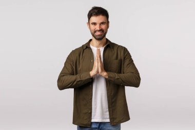 Neşeli, rahat ve dost canlısı gülümseyen beyaz adam dua ederek, sırıtarak, meditasyon yaparak ya da yoga pratiğini bitirerek şükranlarını sunmak için eğilip beyaz arka planda ayakta duran sensei.