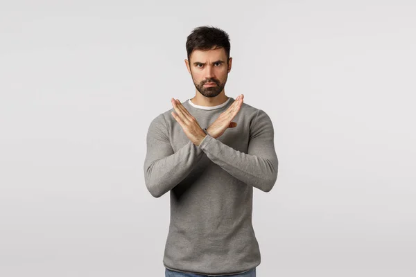 No, never accept it. Serious, confident bearded man in grey sweater, making cross stop gesture, restrict partner doing bad action, give negative reply, refuse or prohibit, white background — Stock Photo, Image