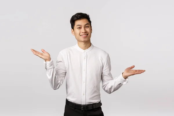 Ανενόχλητος και απρόσεκτος ευτυχισμένος επιτυχημένος νεαρός άνδρας υπάλληλος σε λευκό πουκάμισο, παντελόνι, απλώστε τα χέρια στο πλάι και shrugging με χαλαρή, ανακουφισμένη έκφραση, χαμογελώντας, δεν ξέρω και dont φροντίδα — Φωτογραφία Αρχείου