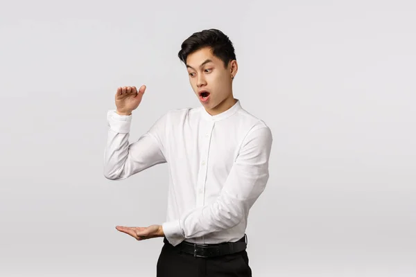 Omg businessman shocked how fast finances increase. Astonished and impressed, excited asian male employee getting rich fast, showing something big, shaping large box, white background — Stock Photo, Image