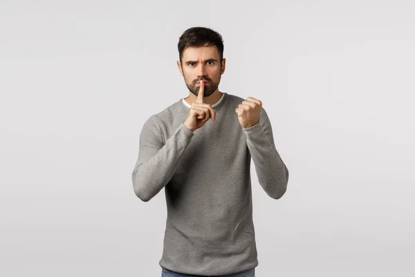 Shut up or else. Threatening angry and serious scary bearded man demand keep silent, dont tell anyone, threaten victim with shaking fist, press index finger to lips, untell, hushing, white background — Stock Photo, Image