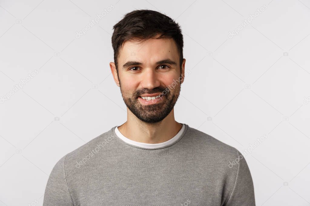 Motivated cheerful and glad, pleasant caucasian adult bearded man in grey sweater, smiling with delighted expression, looking excited and satisfied, nod agreement, give approval, white background