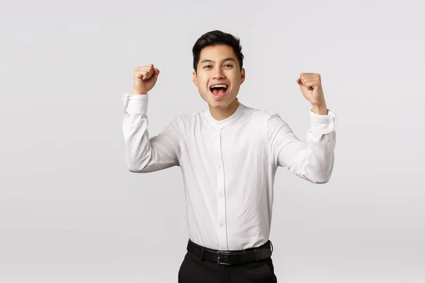 Opgewonden, verheugende jonge Aziatische succesvolle zakenman vieren overwinning, kampioen worden, doel te bereiken, vuist pomp en schreeuwen ja als het gevoel blij, team won, overblijdschap over de overwinning, witte achtergrond — Stockfoto