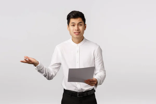 Skeptisk och missnöjd asiatisk manlig entreprenör klagar missnöjd med mottagna dokument, rycka hand i sidled i bestörtning, rynka pannan upprörd, prata med anställda — Stockfoto
