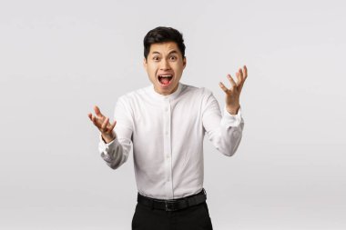 Öfkeli, paniğe kapılmış Asyalı genç adam ne yaptın? Nasıl yaptın? Öfke ve öfkeyle el sıkışıyorsun.