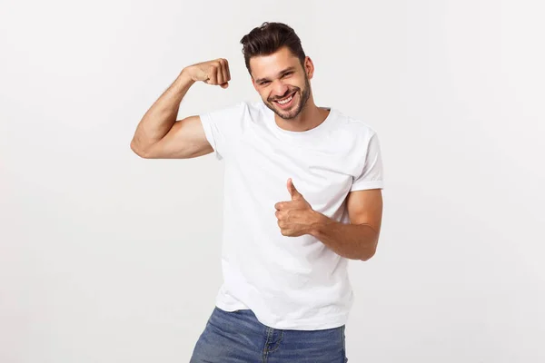 Jóképű fitt fiatal vicces szakállas férfi mutatva bicepsze és mosolygós fehér háttér — Stock Fotó