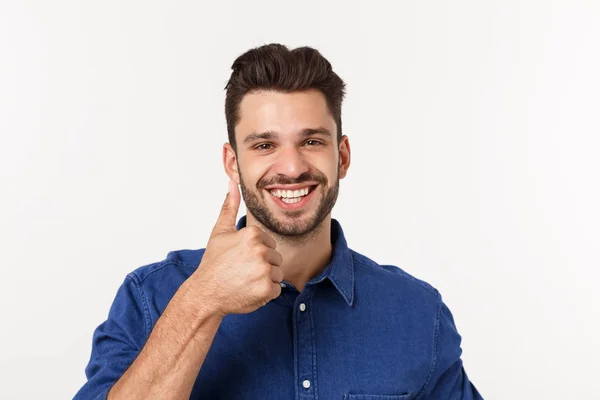 Jovem casual feliz mostrando o polegar para cima e sorrindo isolado no fundo branco . — Fotografia de Stock