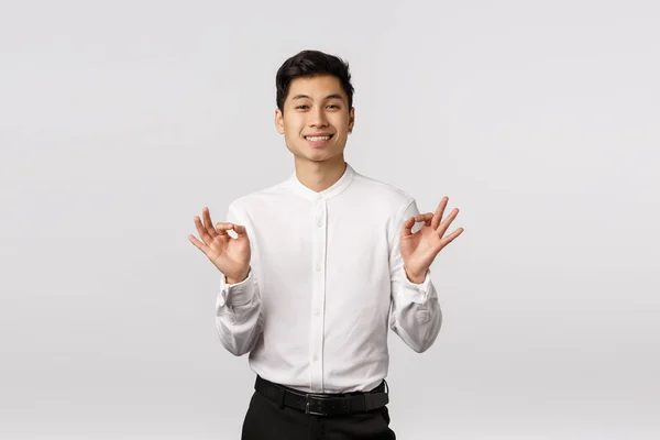 Concepto de éxito, logro y gestos. Guapo joven hombre asiático empresario mostrando bueno, bien o bien gesto, sonriendo en aprobación, como idea, satisfecho con los resultados, fondo blanco — Foto de Stock