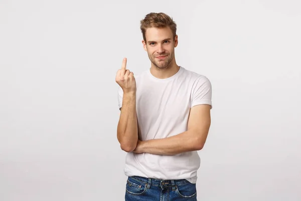 Weet je wat, val dood. Boos knappe blonde agressieve en onbeschofte man met haar, tonen middelvinger, grijns en kijk camera, vertellen tegenstander verdwalen, ruzie hebben, tonen slecht humeur — Stockfoto