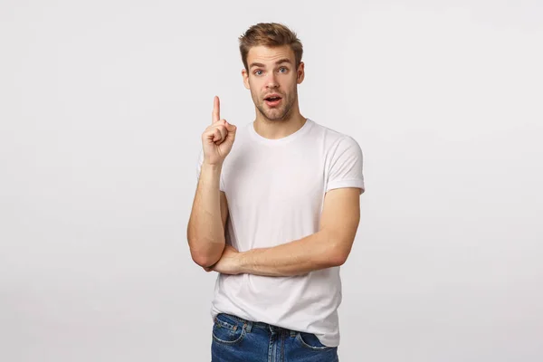 Opgewonden aantrekkelijke blonde man met haar, hebben suggestie, verhogen index vinger eureka gebaar, vragen stellen of spreken, hebben idee, plannen delen, wil iemand hem horen, staan witte achtergrond — Stockfoto