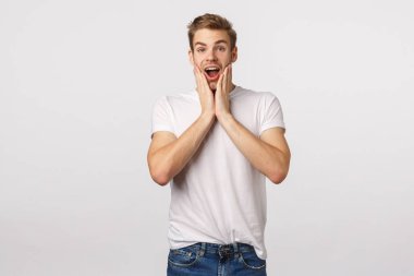 Omg çarpıcı. Heyecanlı ve etkilenmiş, neşeli genç sarışın adam muhteşem bir konsere katılıyor, neşe ve şaşkınlıktan nutku tutuluyor, şaşkın, dokunaklı yanaklar, ağzı açık ve nefes nefese.