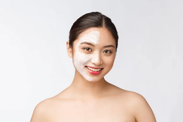 Affascinante donna piacevole applicare la crema su metà faccia — Foto Stock
