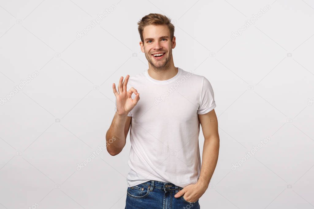Fine, good job, congratulations. Attractive pleased male coworker with blond hair, bristle, showing OK, okay gesture and smiling approval, like plan, rate good movie, leave positive feedback