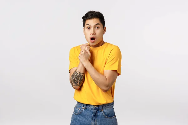 Sensetive and shocked, scared young asian guy with tattoos, pull hand back, press arm to chest insecure and afraid, gasping open mouth, look like victim at someone abuse him, stand white background — Stock Photo, Image