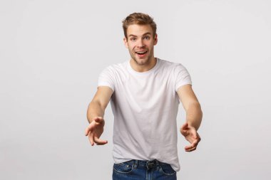 Alabilir miyim? Hayalperest ve neşeli, mutlu, tatlı sarışın adam Noel hediyesi, gizli Noel Baba partisi, bir şeyi yakalamak ya da tutmak için ellerini uzat, neşeyle gülümse ve mutlu ol, beyaz arka plan