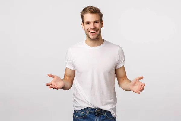 Mann streckt die Hände nach vorne, um etwas zu halten, lehnt sich an Produkt, hilft Freund schwere Kisten tragen, lächelt fröhlich, freundlich nach vorne, steht weißen Hintergrund — Stockfoto