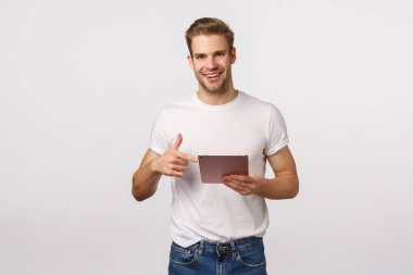 Adam, arkadaşının hali hazırda makaleyi okuyup okumadığını soruyor, elinde dijital tablet ve işaret cihazı var mı, gülümsüyor mu, iş arkadaşıyla fotoğraf görüşüyor mu, uygulama kullanarak planlar yapıyor mu, beyaz arka planda duruyor mu diye soruyor.