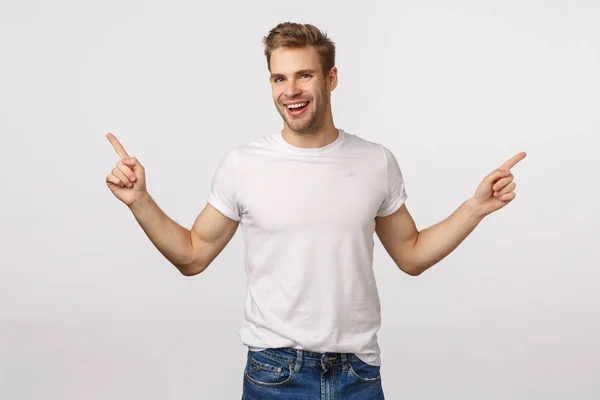 Handsome uitgaande glimlachende blonde blanke man, lachen zorgeloos en blij, hebben grote kansen, twee manieren of keuzes, wijzen zijwaarts, geven advies, show links en rechts product promo — Stockfoto