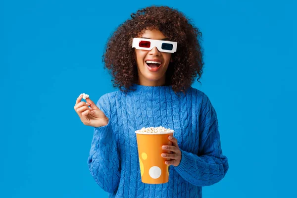 stock image Leisure, lifestyle and modern people concept. Carefree relaxed and joyful, smiling african american woman with afro hairstyle, eating popcorn in cinema, wear 3d glasses and smiling watching movie