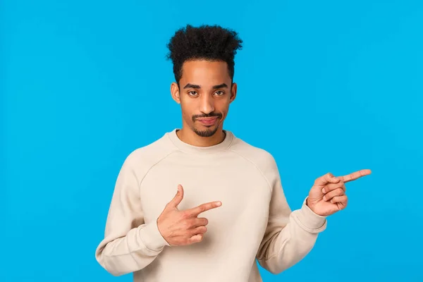 So lahm, gosch. Afro-amerikanischer gutaussehender Mann mit Schnurrbart, Afro-Frisur, skeptisch grinsend, mit sarkastischem Gesichtsausdruck, rechts unzufrieden und unbeeindruckt, blauer Hintergrund — Stockfoto