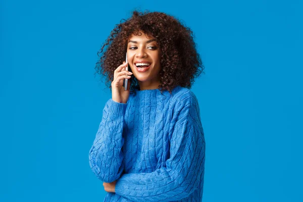 Olá, vem cá. Bonito amigável e carismático mulher afro-americana convidando amigo festa véspera de ano novo, comemorar férias juntos, chamando companheiro no telefone, segurando smartphone e rindo — Fotografia de Stock