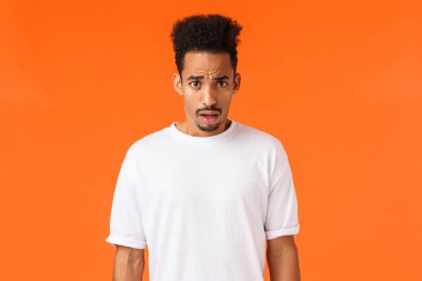 Şaşırmış ve şaşırmış, nutku tutulmuş, Afro-Amerikan erkek bıyıklı, afro saçlı, tiksinti dolu, korkunç manzaralı, ağzı açık, kafası karışmış, hayal kırıklığına uğramış, turuncu bir geçmişi var.