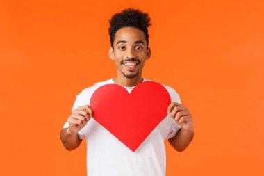 Tutkulu ve mutlu Afrikalı-Amerikalı sevgili, Sevgililer Günü 'nü kutluyor, kalp kartı gösteriyor ve gülümsüyor, sevgisini dile getiriyor, kız arkadaşı olup olmadığını soruyor, ruh eşini arıyor.