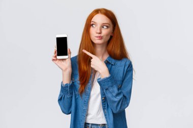 Çekici ve çekici kızıl saçlı kadın yemek dağıtım başvurusunda lezzetli yemekler buldu, alışveriş kartına ekledi, paket almak istedi, akıllı telefon ekranını işaret etti, beyaz arka plan