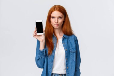 Şımarık ve cesur kızıl saçlı kadının ilginç bir planı var. Dilek listesini gösteriyor. Akıllı telefon ekranından ne aldığını, dudaklarını yaladığını ve umut dolu, beyaz arka planda durduğunu biliyor.
