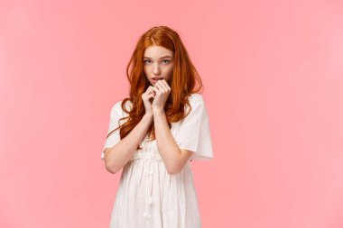 Çekingen kawaii, beyaz elbiseli kızıl saçlı, utangaç ve sevimli, utangaç, alnının altından bakan, pembe arka planda mütevazı duran