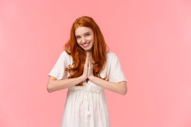 Şehvetli, cilveli, kızıl saçlı bir kız istediğini elde etmek için birini baştan çıkarıyor. Şehvetli bakışlarla yalvarıyor, dua etmek için el ele tutuşuyor, yardım dileniyor, pembe arka plan, lütfen de.