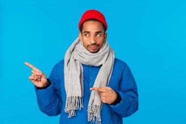 Kulağa sıkıcı geliyor. Yastıklı ceketli, bereli ve eşarplı hoşnutsuz Afro-Amerikan adam, şüpheci ve tatsız bir bakış, sol dikkatsiz, hayal kırıklığına uğramış mavi arka plan