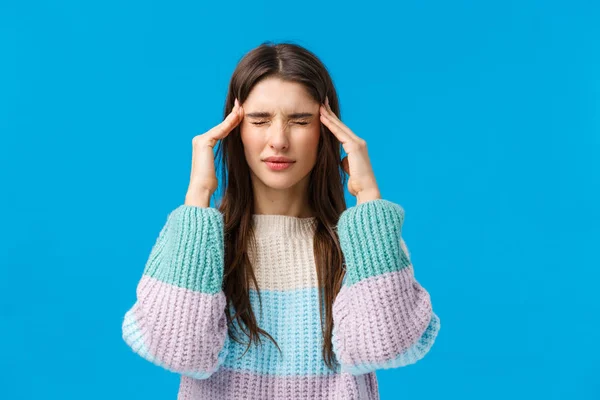 Saúde, médico, conceito de medicina. Cintura-up retrato jovem mulher sentindo-se mal, sofrendo dor de cabeça, tocando templos, agitando de dor e dor de cabeça, de pé fundo azul sentindo-se mal — Fotografia de Stock