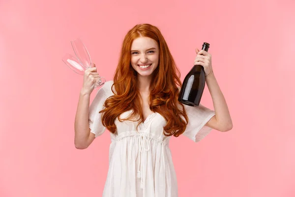 Женщина празднует подписание большого контракта на работе, поздравляет друга, держит два бокала и шампанское, пьет за успех, чувствует себя забавным и радостным, торжествующее достижение, розовый фон — стоковое фото
