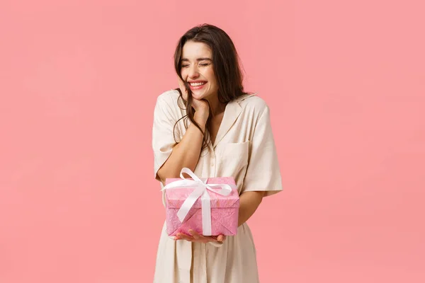 Antecipação, celebração e conceito de festa. Jovem mulher encantadora alegre no vestido, animando os olhos fechados alegremente sorrindo e rindo, recebendo bom presente, tem bonito presente, fundo rosa — Fotografia de Stock