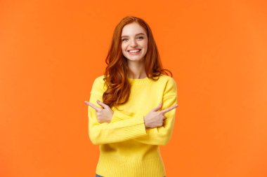 Seçimler, alışveriş, kış tatili konsepti. Kıvırcık saçlı, kıvırcık saçlı, sarı kazaklı, yandan bakan, göğüsten sağa ve sola doğru çapraz ellerle hareket eden tatlı bir kız.